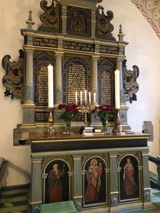 Altar mit Kerzen und Gemälden.