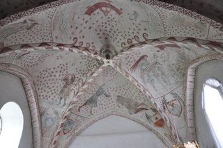 Bemalte Gewölbedecke in einer Kirche.