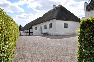 Reetgedecktes Haus mit Kiesweg.